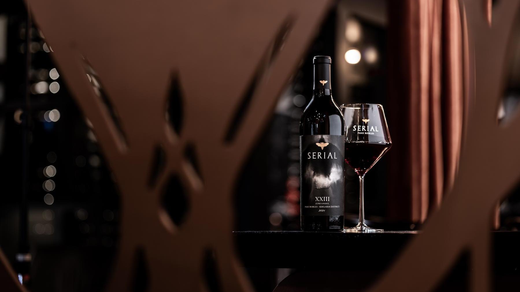 A lineup of bottles showcasing Serial Wines' Spring Release collection, arranged neatly on a wooden table with elegant lighting.