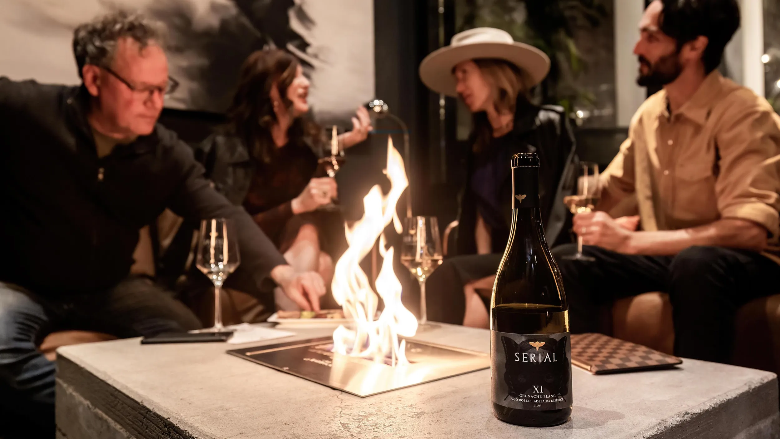 People enjoying Serial wine around a fire